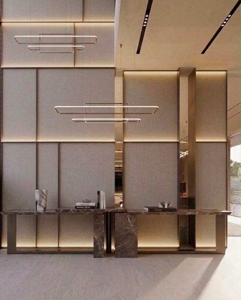 Syrus double-height entrance interior design in Dubai with symmetrical wall panels, stone console and suspended lighting